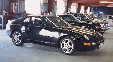 Dick Minesinger
"A total of 12,779 model 968 cars were built. During the production years, 2,417 coupes, model years 1992-1995, were sold in the US. Mine is a '93 black/black coupe which I purchased used in 1996, now with 72,000 miles.

This car has the Sport Chassis option, originally to be designated P30 and available on 1992 models, but actually delayed until the 1993 model year and then called the M30 option. The option includes bigger stabilizer bars, bigger cross-drilled brake discs, adjustable shocks, and 17" wheels. A further option is the limited slip differential. It is essentially track ready.

The engine represents a further development of what had been the 944 S2 engine: 3.0 liter, 4-cylinder, 16 valve, developing 236 HP and 225 ft-lbs of torque.

I love the car. I have frequently run it on race circuits in the US and Canada in DE events sponsored by PCA and trackmasters. It is comfortable for lengthy road trips; it has run in rallies; and it has even done well in the occasional concours. Right now, it is stored for the winter, never having seen a snow flake." - Dick
